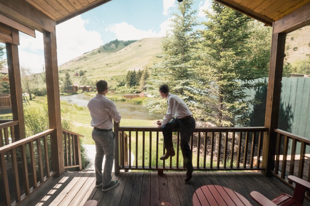 groom and best man admire the view of the Snake River from the Teton Cabins at Diamond Cross Ranch 