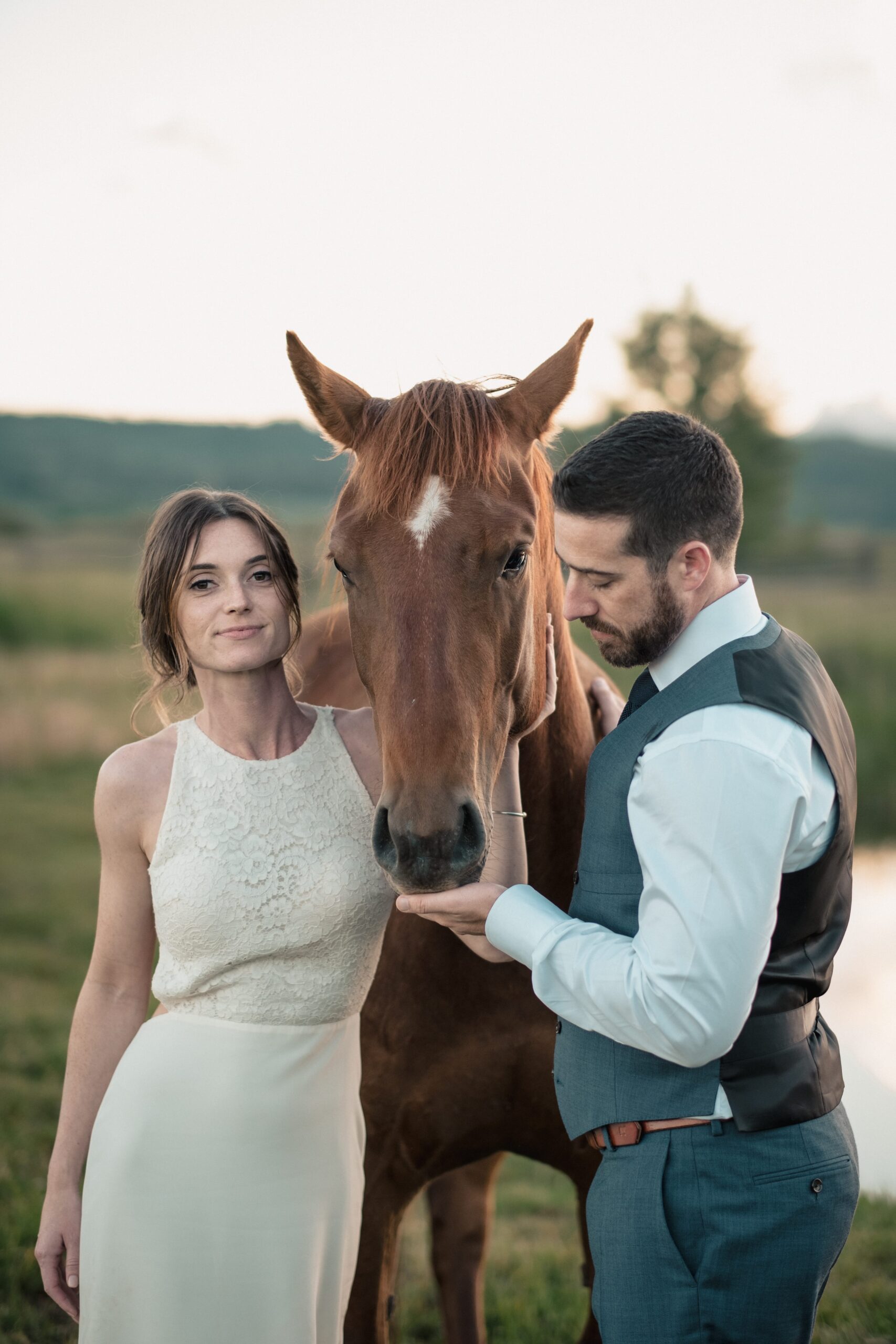 bride and groom pose with a horse at sunset on Diamond Cross Ranch in Jackson Hole